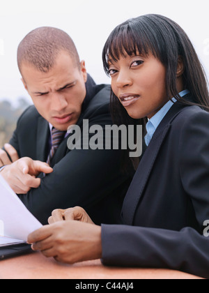 Un imprenditore e imprenditrice revisione di un documento Foto Stock