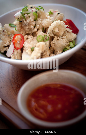 Un piatto di fritti e martoriata calamari calamari, servita con peperoncino, Zenzero cipolline e peperoncino dolce salsa di immersione Foto Stock