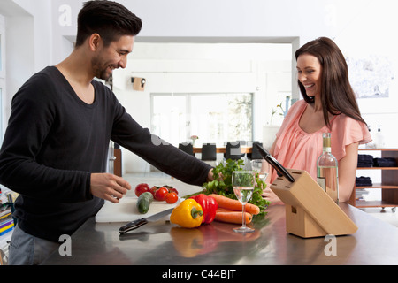 Una giovane coppia di preparare alimenti insieme in un moderno appartamento Foto Stock