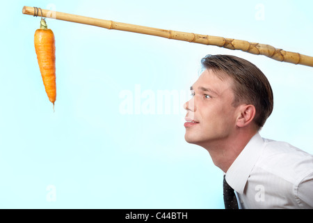 Ritratto di imprenditore guardando carota fresca su angolo Foto Stock