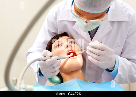 Foto del paziente femmina con dentista oltre il suo controllo su denti e li di perforazione Foto Stock