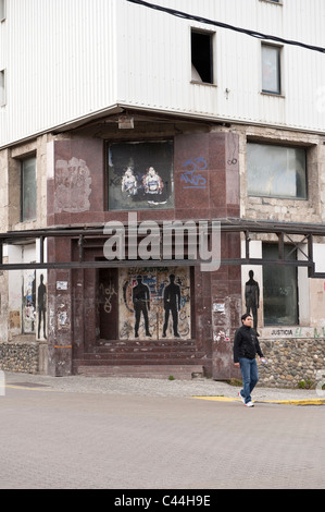 L'uomo cammina sulla parte anteriore dell'edificio decorato con arte di strada Ushuaia, Tierra del Fuego, Argentina, Sud America Foto Stock