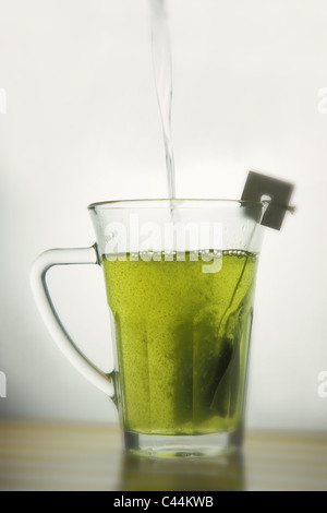 versare acqua calda in una tazza di tè verde sencha matcha. Isolato, copia-spazio. Foto Stock