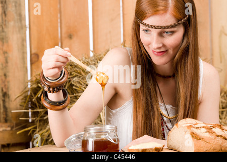 Giovani red-capelli donna hippie prima colazione biologica in un fienile in stile country Foto Stock