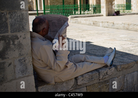 Uomo legge quotidiano arabo al di fuori della Moschea di Al-Aqsa sul Monte del Tempio. Gerusalemme, Israele. 2 Giugno 2011. Foto Stock