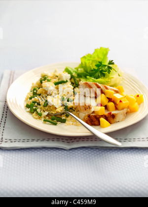 Bulgur di grano, feta, pollo e mango sulla piastra, close-up Foto Stock