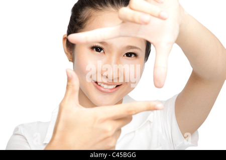 Ritratto di giovane sorridente donna fare un telaio a mano isolato su bianco Foto Stock