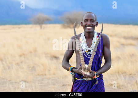 Tutti i sorrisi: Koike Parsaloi, una guida Masai con la Shompole Lodge in Kenya, pause per una foto nella Grande Rift Valley. Foto Stock