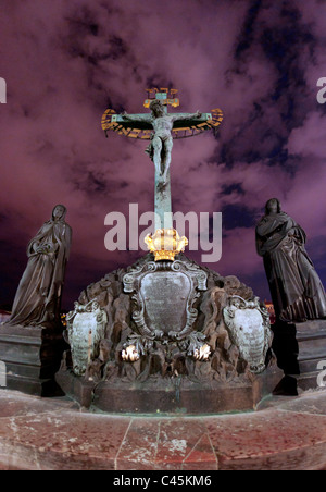 Statua di Gesù crocifisso sul Ponte Carlo a Praga Repubblica Ceca, con il cielo notturno e le nuvole. Foto Stock