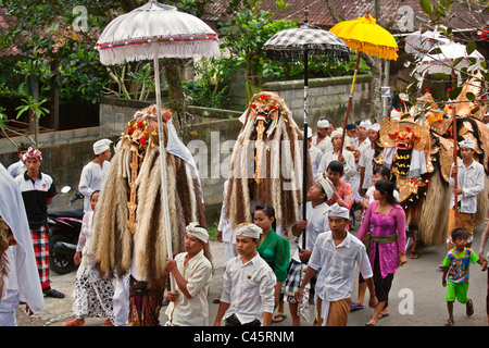 Un costume BARONG E LION maschere utilizzate in ballo LEGONG durante una processione indù per un tempio anniversario : Ubud, Bali Foto Stock