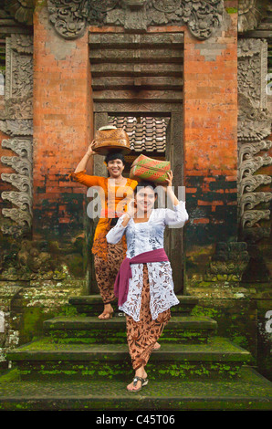 Donna balinese portano offerte in posizionedi tempio indù di pura DESA durante il GALUNGAN FESTIVAL - Ubud, Bali, Indonesia Foto Stock