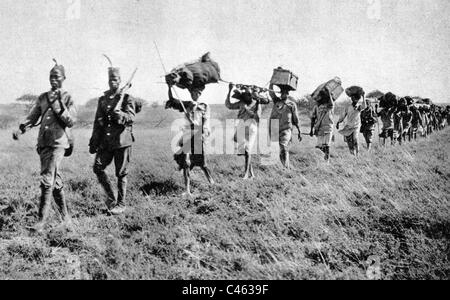 Colonna di segnalatori acustici Askari portatori in tedesco in Africa orientale Foto Stock