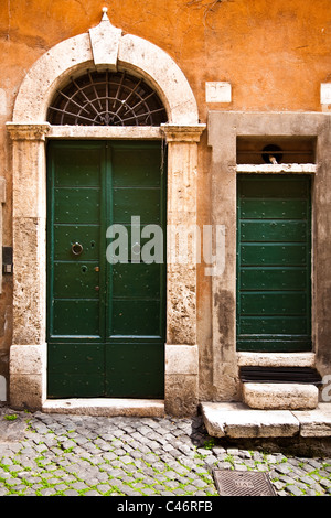 Una coppia di porte verdi nel quartiere Monti di Roma, Italia Foto Stock