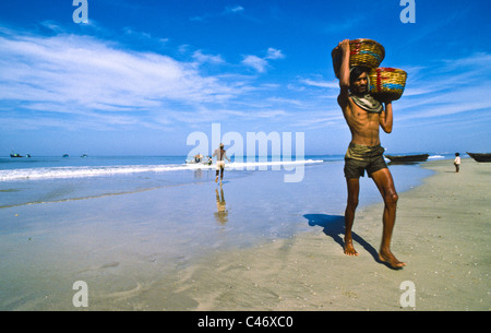 Cestini di scarico del pesce dalle barche sulla spiaggia di Calva in Goa, India Foto Stock