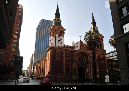 Blue sky sole di mattina ombra vista giallo rosso dei mattoni neo-classico della Basilica de la Marced sotto i moderni grattacieli, Santiago del Cile Foto Stock