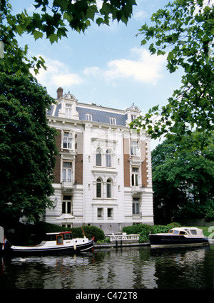 Barche in legno dock sui canali di fronte olandese tetto a capanna case Foto Stock