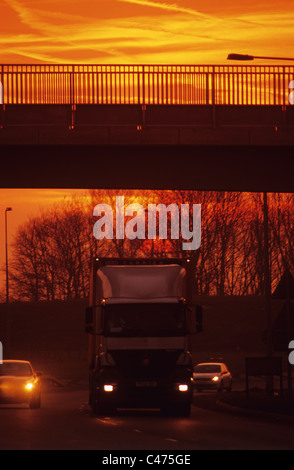 Camion e automobili viaggia su una strada a doppia carreggiata al tramonto Leeds Yorkshire Regno Unito Foto Stock