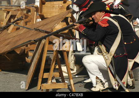 Gli uomini maltesi vestiti come soldati della guarnigione francese prendono parte alla rievocazione storica dell'assalto dei francesi sotto Napoleone (1798-1800) e all'arrivo degli inglesi che hanno aiutato a battere i francesi durante il Carnevale maltese nell'isola di Malta Foto Stock