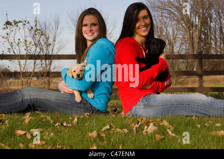 Due teen-bambine tenere Labrador retriever cuccioli Foto Stock