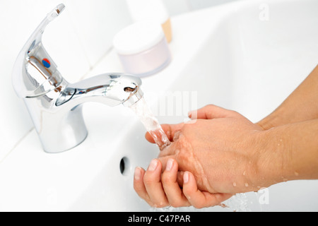 Close-up di mani umane essendo lavato sotto flusso di acqua pura da toccare Foto Stock