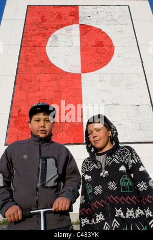 Due ragazzi locali di fronte a un grande dipinto della bandiera della Groenlandia in Nuuk, Groenlandia Foto Stock