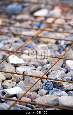 Il rinforzo del cemento armato di maglia di acciaio raffigurato su hardcore ( mattoni rotti, macerie) Foto Stock