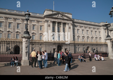 I turisti di fronte alle principali ringhiere fuori Buckingham Palace, London, Regno Unito. Foto Stock