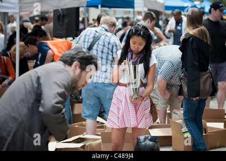 Gli amanti dello shopping ricerca di occasioni tra il caos delle opere di alloggiamento street fair in New York quartiere di Soho Foto Stock