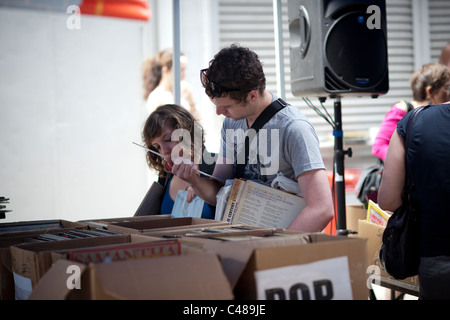 Gli amanti dello shopping ricerca di occasioni tra il caos delle opere di alloggiamento street fair in New York quartiere di Soho Foto Stock