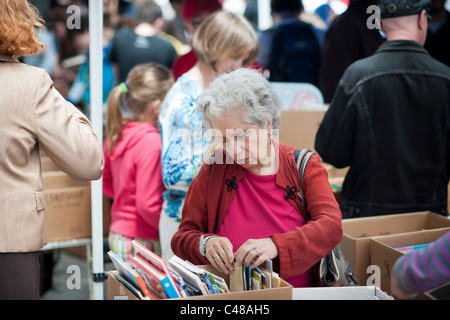 Gli amanti dello shopping ricerca di occasioni tra il caos delle opere di alloggiamento street fair in New York quartiere di Soho Foto Stock