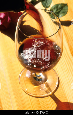 Il vino rosso è versata in un bicchiere Foto Stock