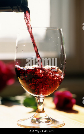 Il vino rosso è versata in un bicchiere Foto Stock