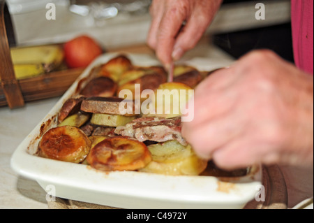 Femmina - pensionati anziani che serve un Lancashire hot pot tradizionale per la cena REGNO UNITO Foto Stock