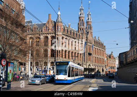 Il tram di fronte al centro commerciale Magna Plaza (un ex ufficio postale), Nieuwezijds Voorburgwal, Amsterdam, Paesi Bassi Foto Stock