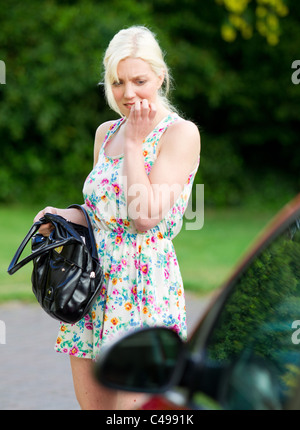 Donna che guarda per la sua perdita delle chiavi Foto Stock