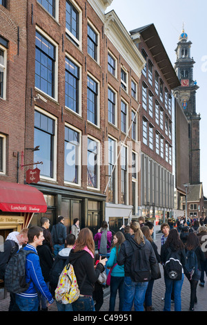 I turisti di fronte alla casa di Anna Frank su Prinsengracht con torre di Westerkerk (Westertoren) dietro, Amsterdam, Paesi Bassi Foto Stock