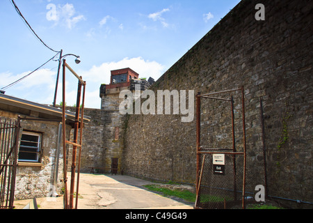 Una torre di guardia e di un alto muro cellblocks surround a stato orientale penitenziario. Foto Stock