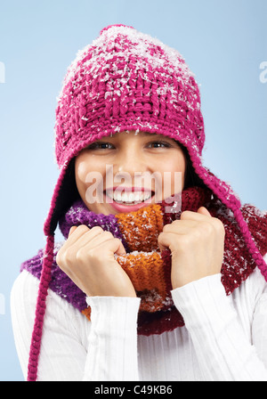 Volto di donna graziosa in maglia inverno cappello e sciarpa guardando la fotocamera con un sorriso Foto Stock