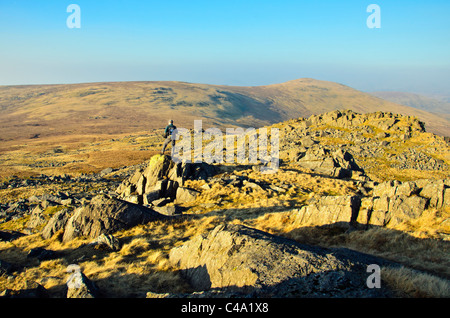 Il camminatore solitario sul Buckbarrow, guardando verso la masterizzazione di Moro e Whitfell, all'angolo sud-ovest del Distretto del Lago Foto Stock