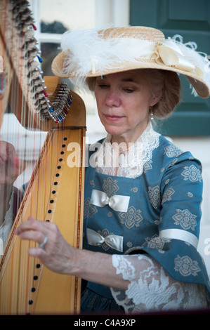 Una Donna vestita nel XVIII secolo abbigliamento suonare l'arpa a Mount Vernon Estate in Alexandria, Virginia. Foto Stock