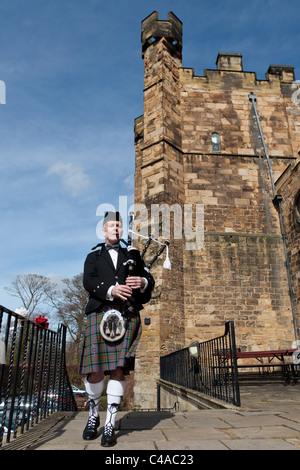 Un piper in uniforme Riproduzione di cornamuse sui gradini di fronte Lumley castle in Chester le street Durham, (modello di rilascio forse ok) Foto Stock