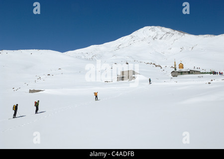 Un gruppo di alpinisti di sci sci fino al Saheb al Zaman moschea di Mt Damavand nel Alburz montagne dell'Iran in inverno. Foto Stock