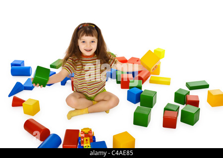 Bambina gioca con cubi colorati sul pavimento isolato su sfondo bianco Foto Stock