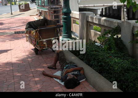 Uomo che dorme sul marciapiede, Bangkok, Thailandia. Foto Stock