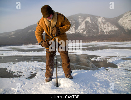 La Russia, Siberia, Baikal; subendo i preparativi per la pesca sul lago ghiacciato baikal in inverno Foto Stock