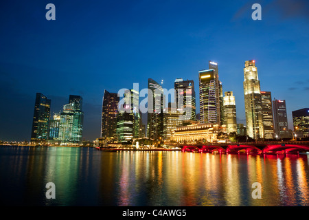 Singapore, Singapore, Marina Bay. Il quartiere centrale degli affari skyline al tramonto. Foto Stock