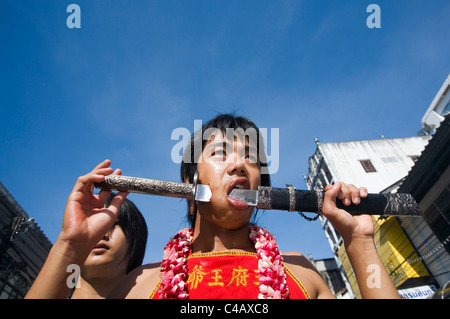 Thailandia, Ko Phuket Phuket. Un Ma-Thong (media di spirito) con le guance trafitto da una spada durante il Phuket Festival vegetariano. Foto Stock