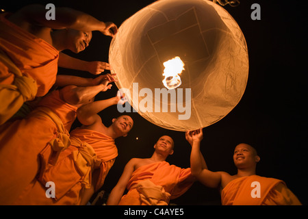 Thailandia Chiang Mai, San Isc. I monaci lanciare un khom loi (sky) lanterna durante il Yi Peng festival. Foto Stock