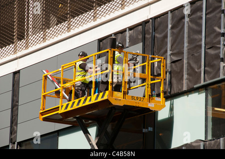 I lavoratori su una piattaforma di accesso al MediaCityUK sviluppo, Salford Quays, Greater Manchester, Inghilterra, Regno Unito Foto Stock