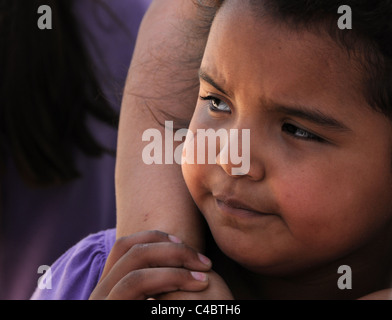 Una giovane ragazza, che si aggrappa a sua madre in Altare, Sonora, Messico, spera di migrare verso gli Stati Uniti. Foto Stock